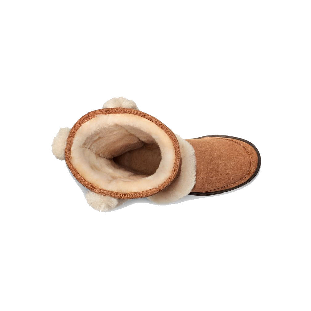 Top view of a brown suede boot with white fur lining and pom-poms, showing the interior detail and luxurious Twinface sheepskin of the UGG SUNBURST TALL CHESTNUT - WOMENS by Ugg.