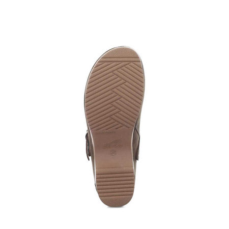 Bottom view of a brown Dansko shoe showing a detailed tread pattern and design markings on the sole, featuring an adjustable ankle strap for a secure fit. The product is the DANSKO BERRY MUSHROOM BURNISHED - WOMENS.