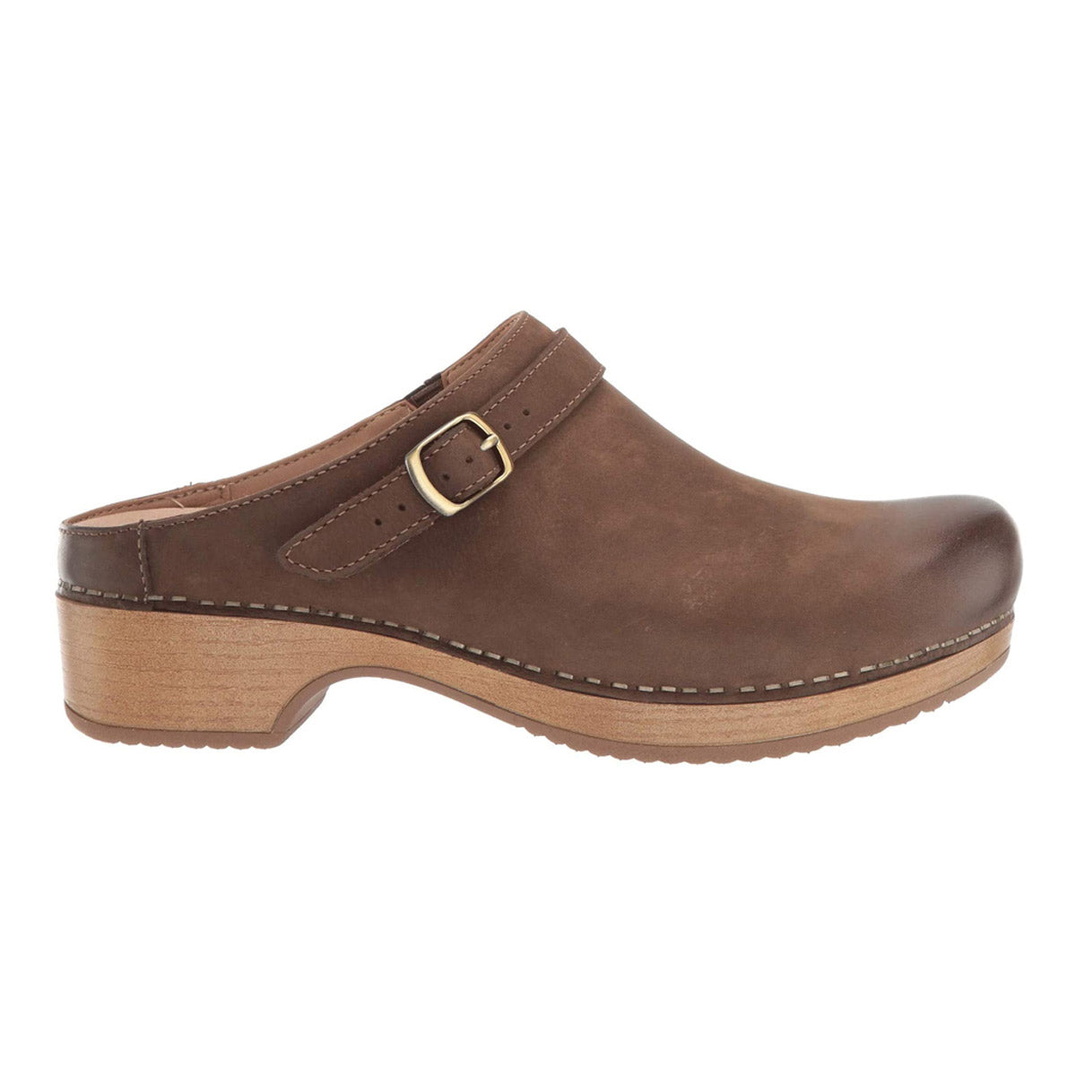 A brown leather clog with a wooden heel, featuring a side buckle and white stitching along the edges. The Dansko DANSKO BERRY MUSHROOM BURNISHED - WOMENS design includes an adjustable ankle strap for a customized fit and odor control technology for all-day comfort.