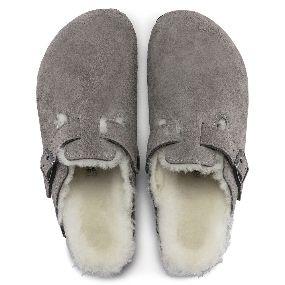 A pair of Birkenstock BIRKENSTOCK BOSTON SHEARLING STONE COIN - WOMENS clogs with a suede and shearling footbed, buckle straps, and an anatomically formed cork-latex footbed, viewed from above.