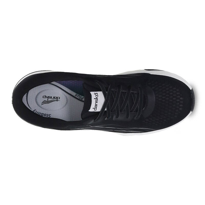 Top view of the DANSKO PACE BLACK MESH - WOMENS walking shoe by Dansko, featuring a sleek black athletic design with a contrasting white sole. The image highlights the laces, interior label, and breathable mesh upper. Engineered for optimal comfort and support with Natural Arch Plus technology.