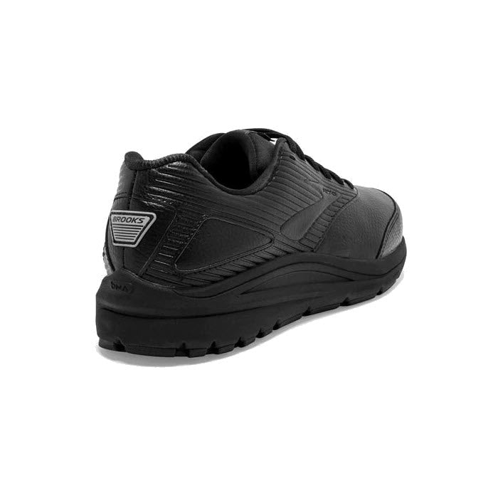 The Brooks Addiction Walker 2 Lace Black walking shoe for women, seen from the back, features a textured design with a rubber outsole, branded tag on the heel, and a Progressive Diagonal Rollbar (PDRB) for added support.