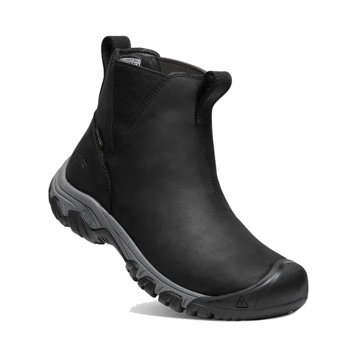 Introducing the KEEN GRETA BLACK/STEEL GREY - WOMENS: a sleek black slip-on work boot featuring a rugged sole, convenient pull tabs, reinforced toe, and KEEN.WARM insulation for extra warmth.