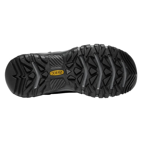 The image shows the sole of a KEEN GRETA Black/Steel Grey winter boot, specially designed for women, featuring a rugged tread pattern and a prominent yellow &quot;KEEN&quot; logo at the center. This waterproof boot by Keen is built to provide superior traction in icy conditions.