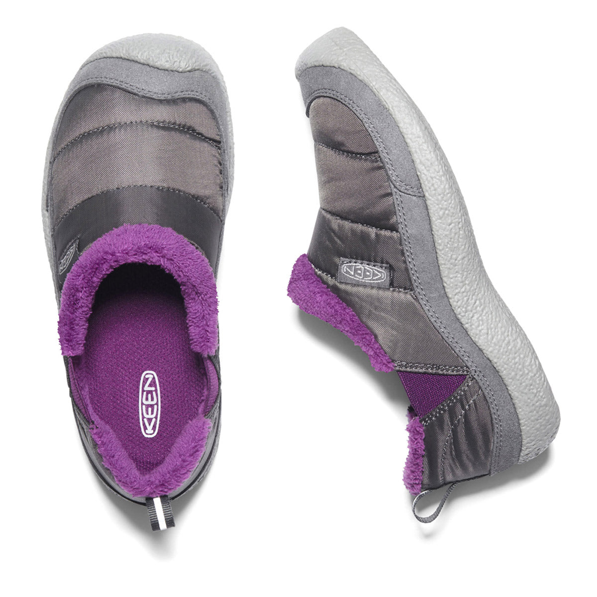 Two slip-on shoes in the KEEN HOWSER II CHILD STEEL GREY/WOOD VIOLET colorway offer ultimate step-in comfort with plush lining. One shoe stands upright, showcasing the Keen logo, while the other lies on its side, revealing the sole. The lightweight performance mesh enhances the appeal of these comfy Keen shoes for kids.