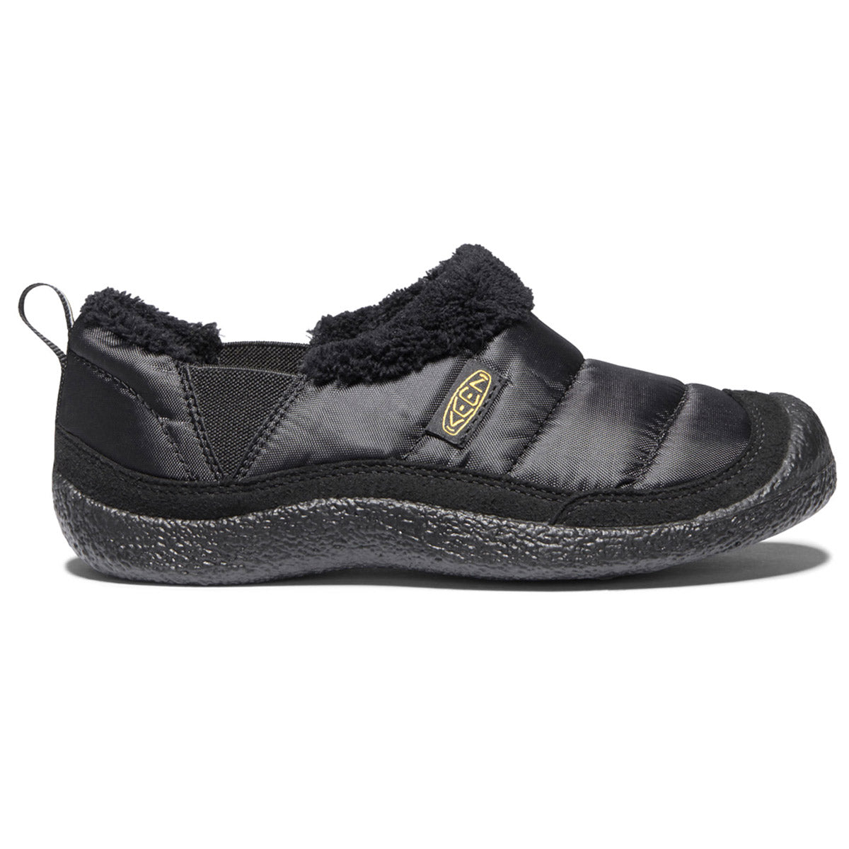 The KEEN HOWSER II CHILD BLACK - KIDS by Keen is a black slip-on comfy shoe featuring a padded upper, textured outsole, and plush lining. The shoe includes a pull tab at the heel, natural odor control, and a logo on the side—a perfect blend of comfort and practical design similar to its adult counterpart.