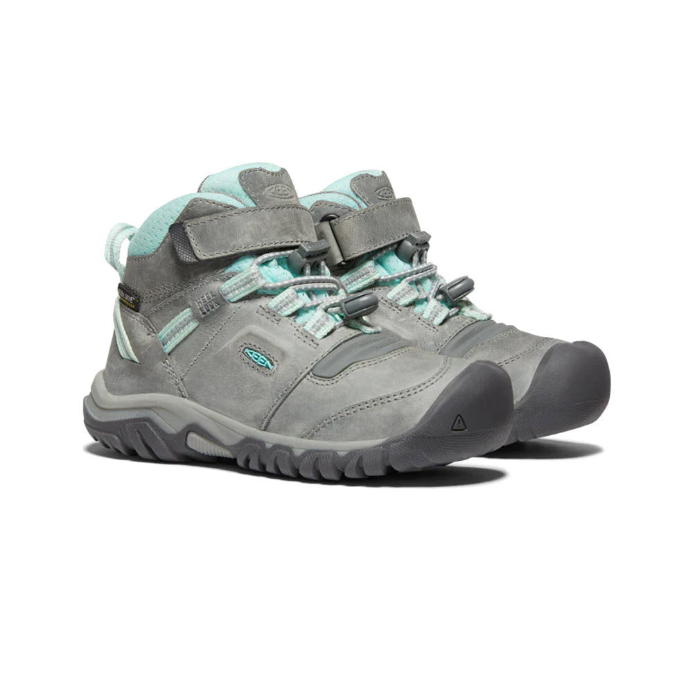A pair of KEEN RIDGE FLEX MID CHILD GREY/BLUE TINT - KIDS from Keen, with rugged soles and a padded collar, featuring a pull-cinch closure, are shown against a white background.