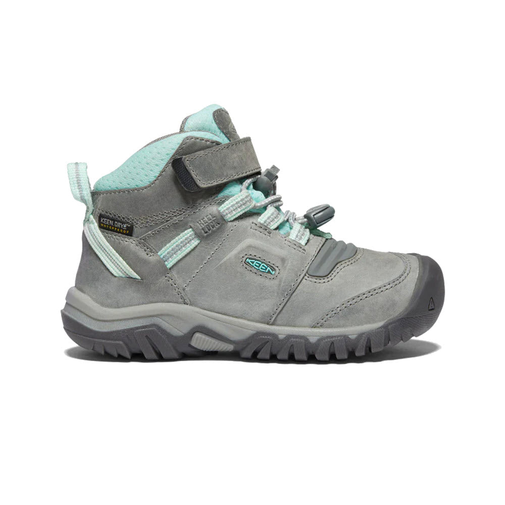 A single grey and mint green kids&#39; hiking boot, known as the Keen KEEN RIDGE FLEX MID CHILD GREY/BLUE TINT - KIDS, features a rugged sole, padded collar, and Velcro strap. It is shown against a white background.