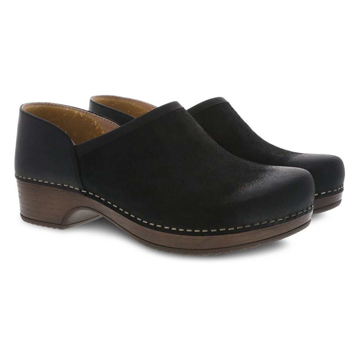 A pair of DANSKO BRENNA BLACK BURNISHED SUEDE - WOMENS with a wooden heel and white stitching along the bottom edge, offering the perfect blend of comfortable casual footwear and easy slip-on shoe design by Dansko.