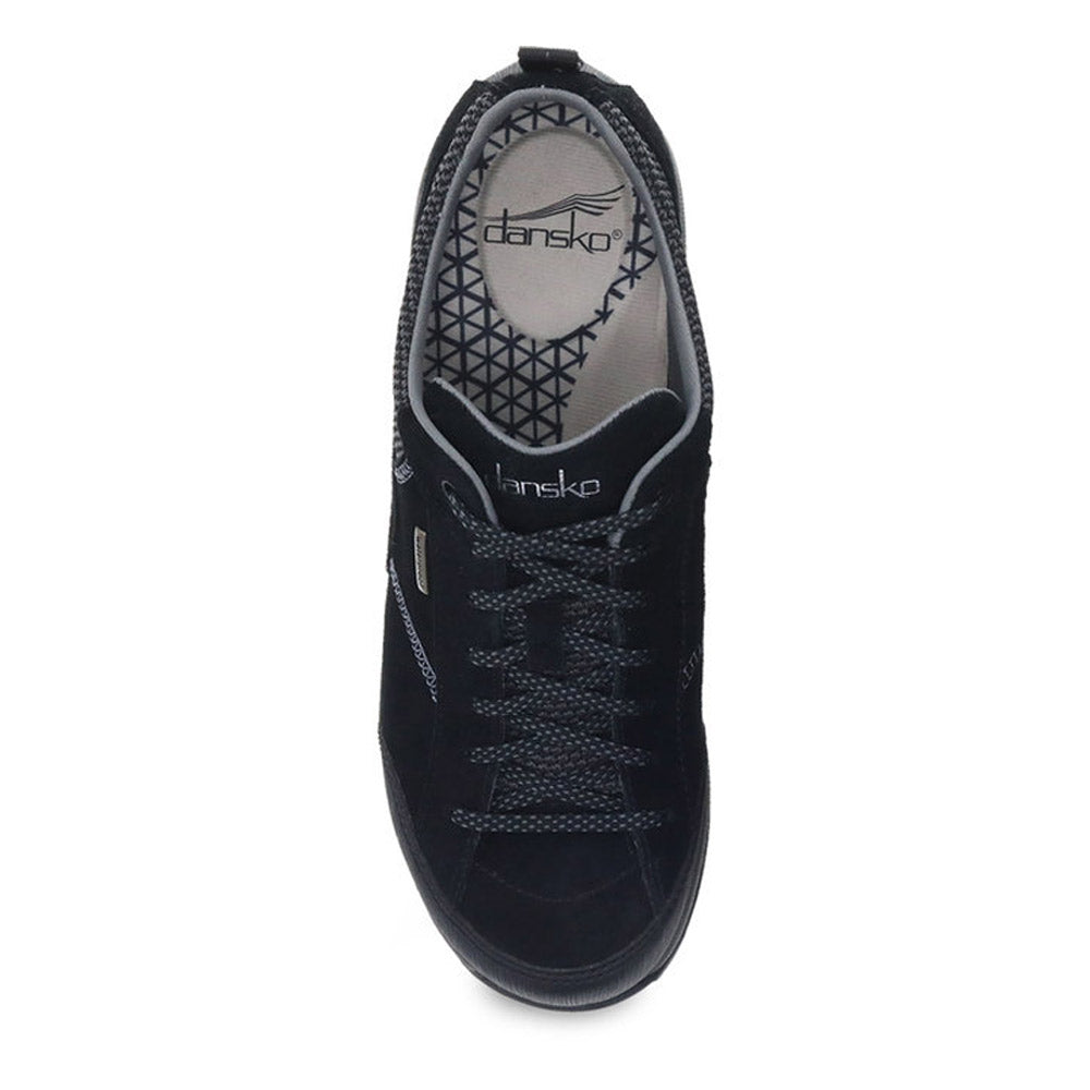 Top view of a black DANSKO PAISLEY BLACK/BLACK SUEDE - WOMEN walking shoe with grey laces and a geometric pattern on the insole. The brand name &quot;Dansko&quot; is visible on the insole and the side of the shoe.