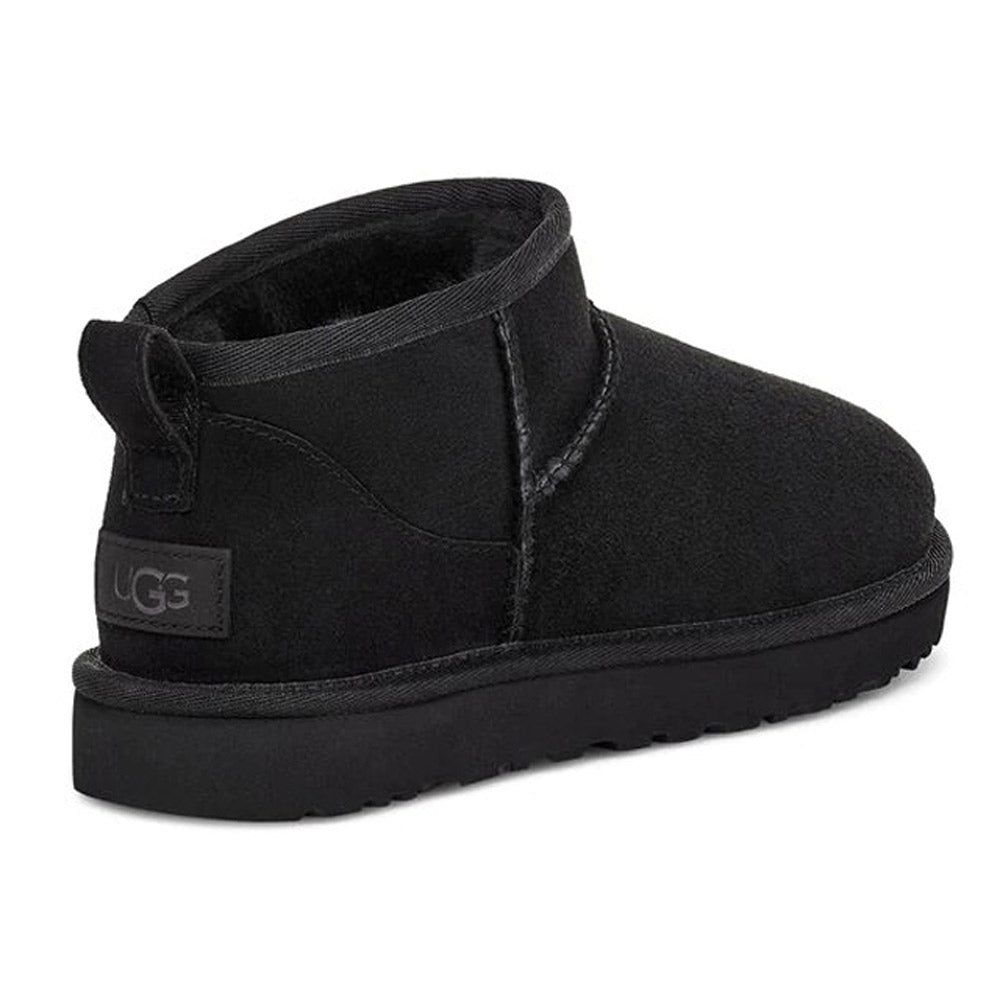 An UGG CLASSIC ULTRA MINI BLACK - WOMENS boot with a thick Treadlite by Ugg sole and a pull tab at the heel, featuring luxurious Twinface sheepskin.