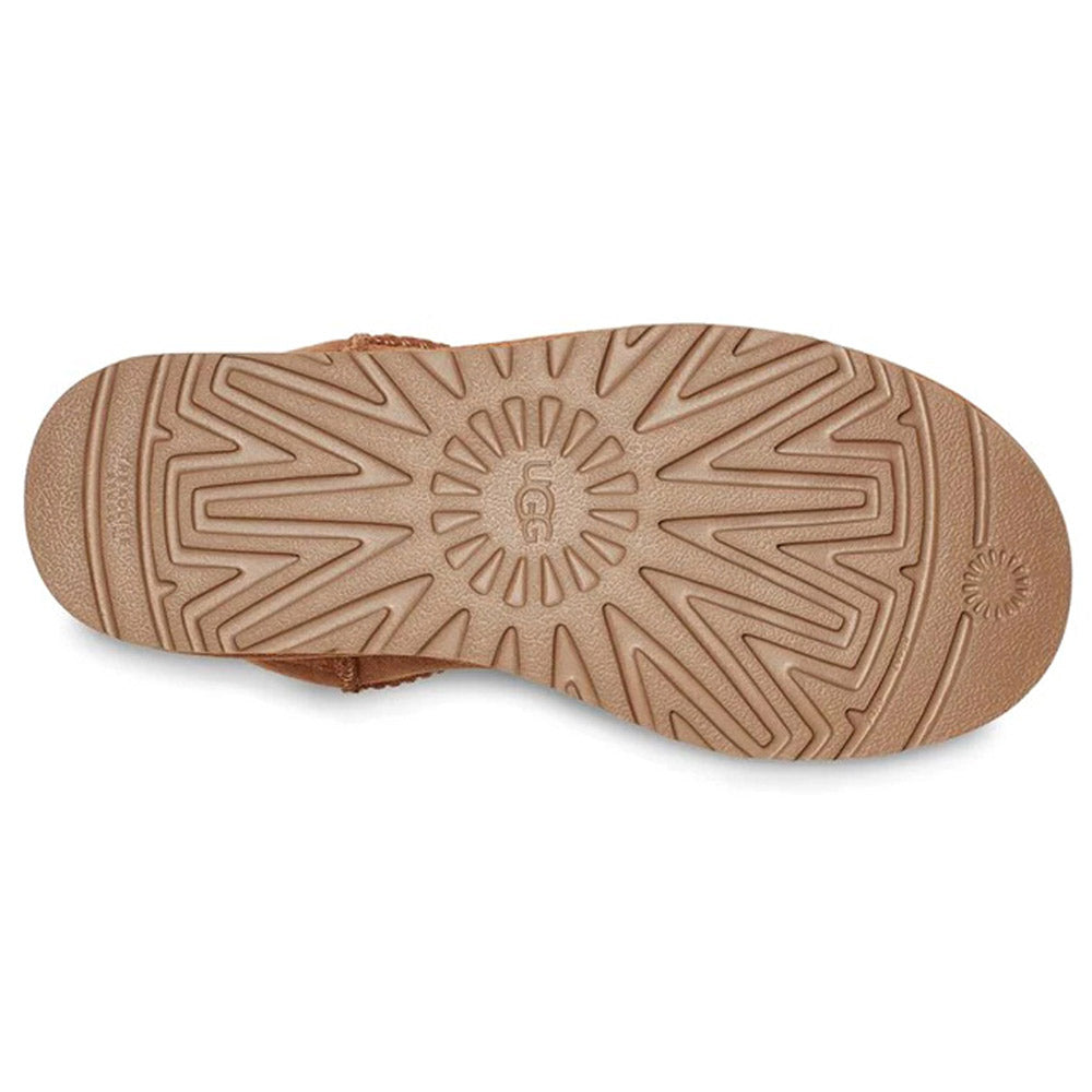 A close-up of the sole of a beige UGG CLASSIC ULTRA MINI CHESTNUT - WOMENS shoe shows the intricate tread pattern, crafted with Treadlite by Ugg technology, and the Ugg logo in the center.