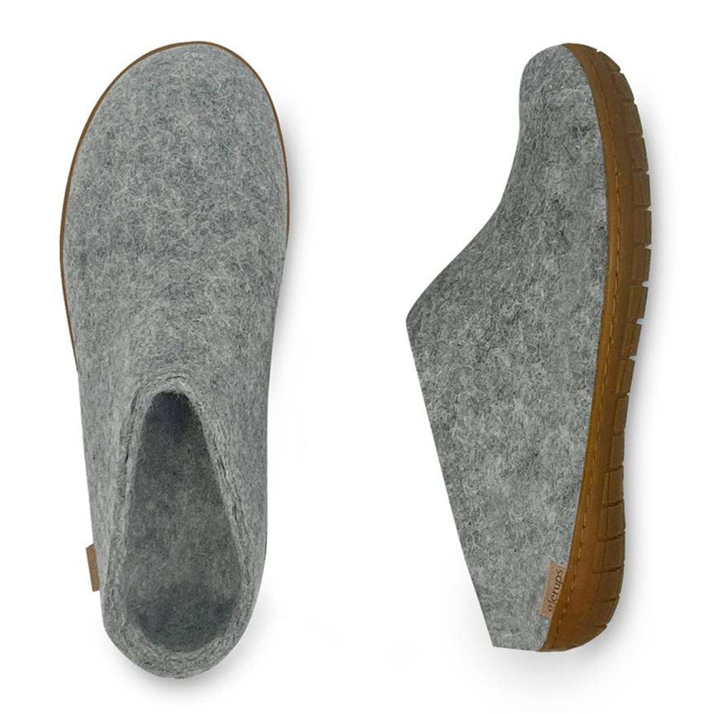 A pair of Glerups GLERUPS THE SLIP-ON RUBBER HONEY GREY - ADULTS made from natural wool, featuring gray felt uppers and brown rubber soles, viewed from the side and top.