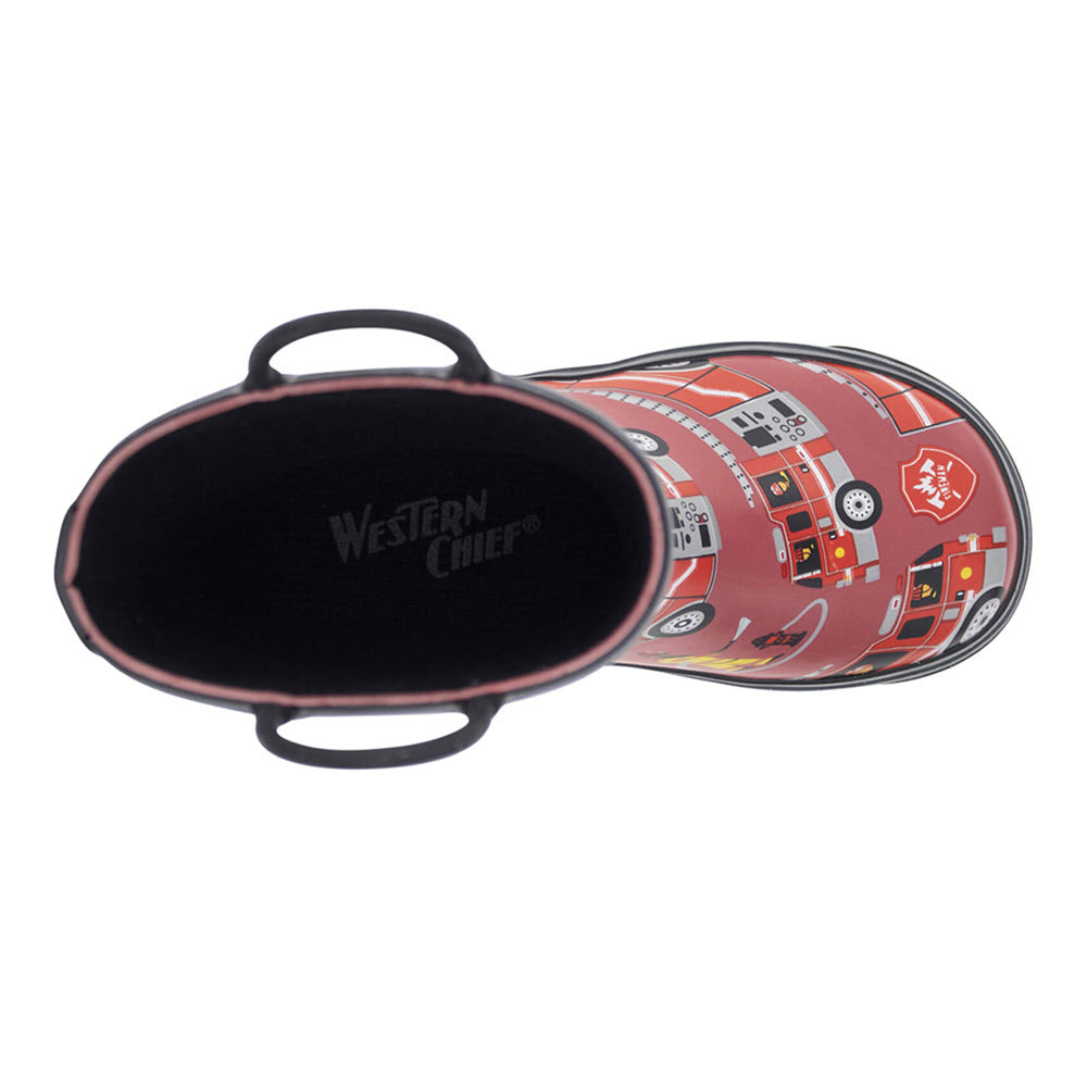 A top view of the &#39;Western Chief Fire Truck Rescue Red - Kids&#39; rain boot, ideal for rainy and muddy days, featuring a pattern of vehicles and emergency symbols like fire trucks, with black handles on each side of the opening.