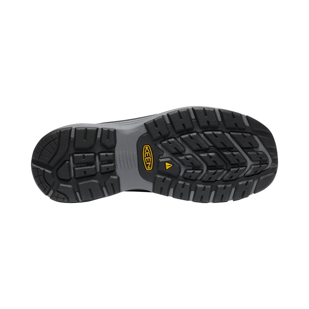 The image shows the outsole of a black and gray rugged Keen Sparta II Men&#39;s Safety Toe shoe, featuring deep treads for enhanced traction and a yellow logo near the arch.