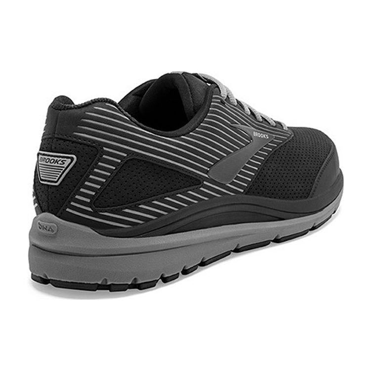 A single black and gray BROOKS ADDICTION WALKER SUEDE BLACK/PRIMER - MENS with a sleek design, shown from a rear side angle, featuring runner-tech cushioning by Brooks.