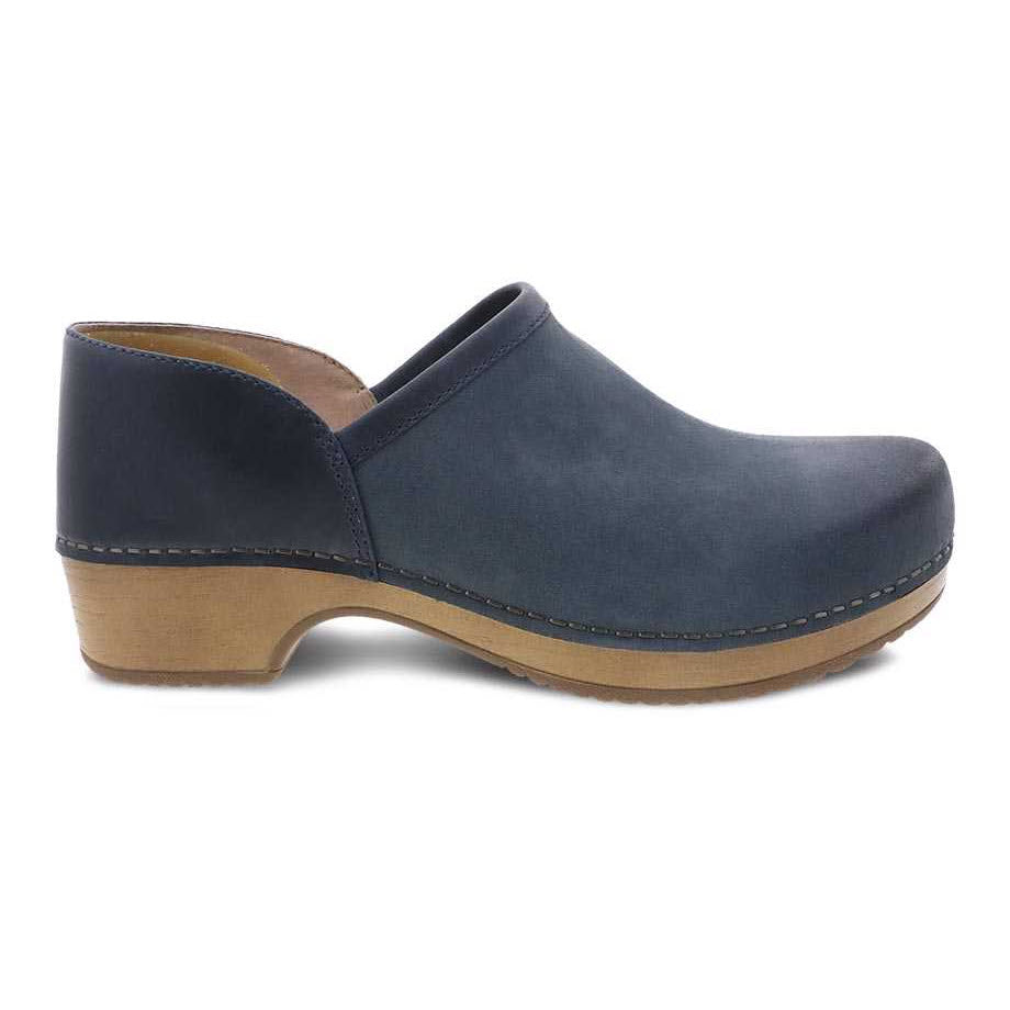 The DANSKO BRENNA NAVY BURNISHED for women by Dansko is a dark blue, comfortable slip-on clog featuring a wooden sole, slightly raised heel, and built-in odor control.