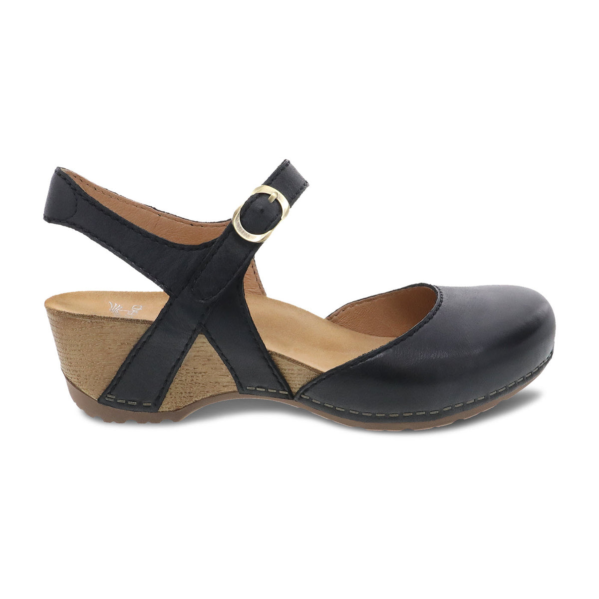 The Dansko DANSKO TIFFANI BLACK - WOMENS is a black, leather, low-heel shoe with a round toe, ankle strap, and cork sole. The burnished leather uppers feature a gold buckle on the strap and a contoured footbed with memory foam for added comfort.