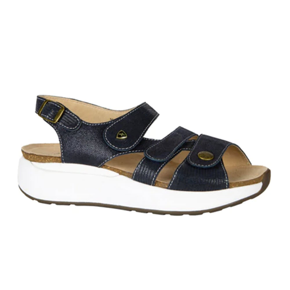 A navy embossed leather sandal with adjustable straps, a cushioned insole, and a white wedge sole, offering both stability and cushioning from the Xelero Mykonos collection for women.