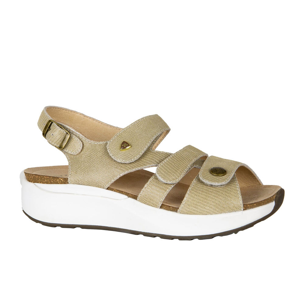 The Xelero Mykonos Champagne Embossed Leather women&#39;s sandal features a beige open-toe design with a white platform sole. It includes three adjustable velcro straps, a gold buckle on the back strap, and extra deep footbeds for added comfort.