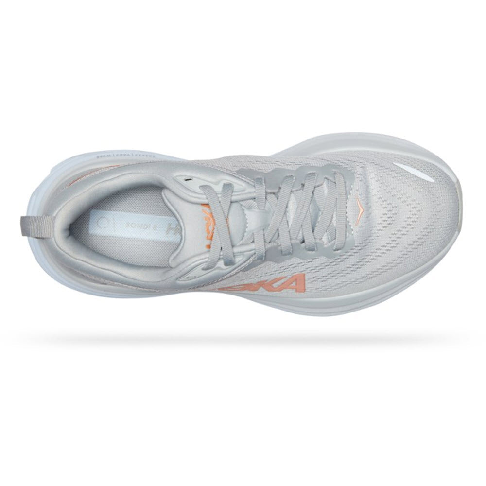 Top view of the HOKA ONE ONE BONDI 8 running shoe in Harbor Mist/Lunar Rock colorway, showcasing a light grey design with orange accents on the tongue and sides. This Hoka women&#39;s shoe features a lace-up design, mesh upper, and padded collar. These ultra-cushioned shoes are specifically designed to enhance foot health while providing exceptional comfort.