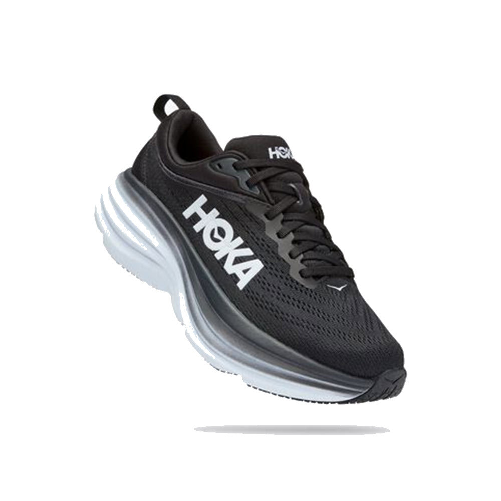 A HOKA ONE ONE BONDI 8 BLACK/WHITE - WOMENS running shoe from Hoka is floating on a white background. The ultra-cushioned sole ensures exceptional comfort, promoting foot health with every step. The shoe features a prominent logo on the side, highlighting its design excellence.