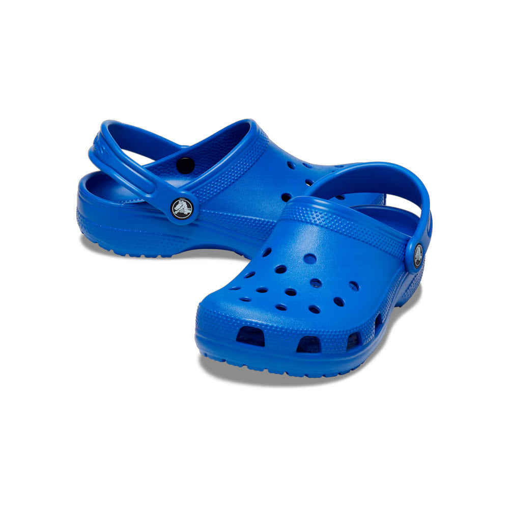 A pair of CROCS CLASSIC CLOG BLUE BOLT - KIDS with heel straps and ventilation holes, showcasing the iconic Crocs comfort against a white background.