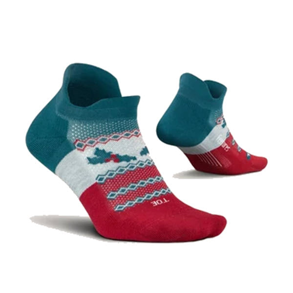 A pair of Christmas-themed ankle socks featuring a mix of red, green, and white colors with festive patterns including reindeer and zigzags, these Feetures FEETURES NO SHOW SOCKS MISELTOE - WOMENS also offer light cushion and a no-show tab for comfortable wear.