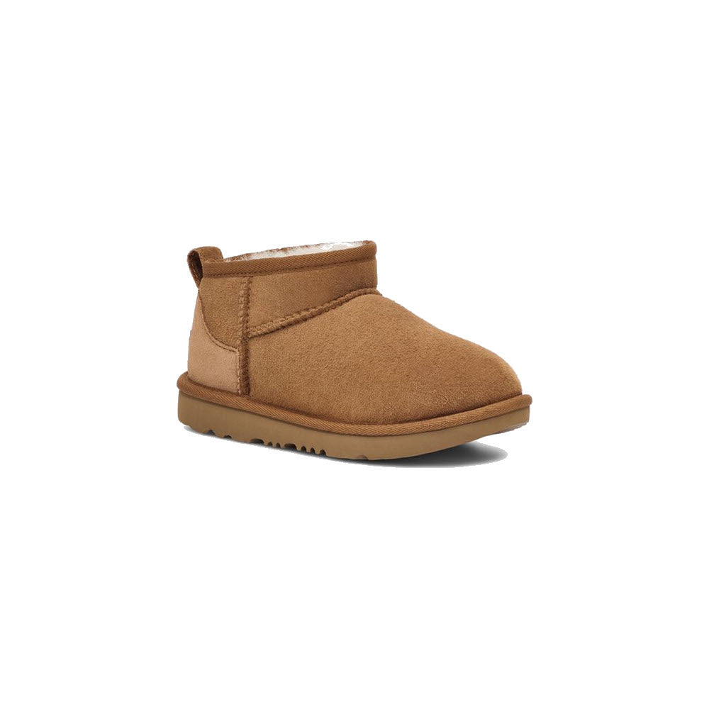 A single light brown suede UGG CLASSIC ULTRA MINI CHESTNUT - KIDS ankle boot by Ugg with a flat rubber sole, sheepskin lining for comfort, and a loop at the back, perfect for all-day play.