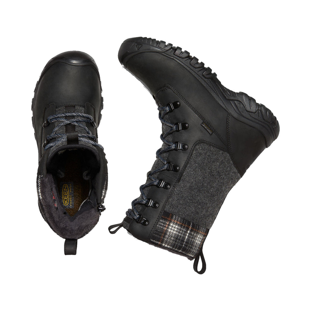 A pair of KEEN Greta Tall Boot WP Black - Women&#39;s boots feature a stylish black and gray design with a plaid pattern near the top. One boot stands upright, while the other lies on its side, revealing the sole and inside lining designed for optimal cold-weather traction.