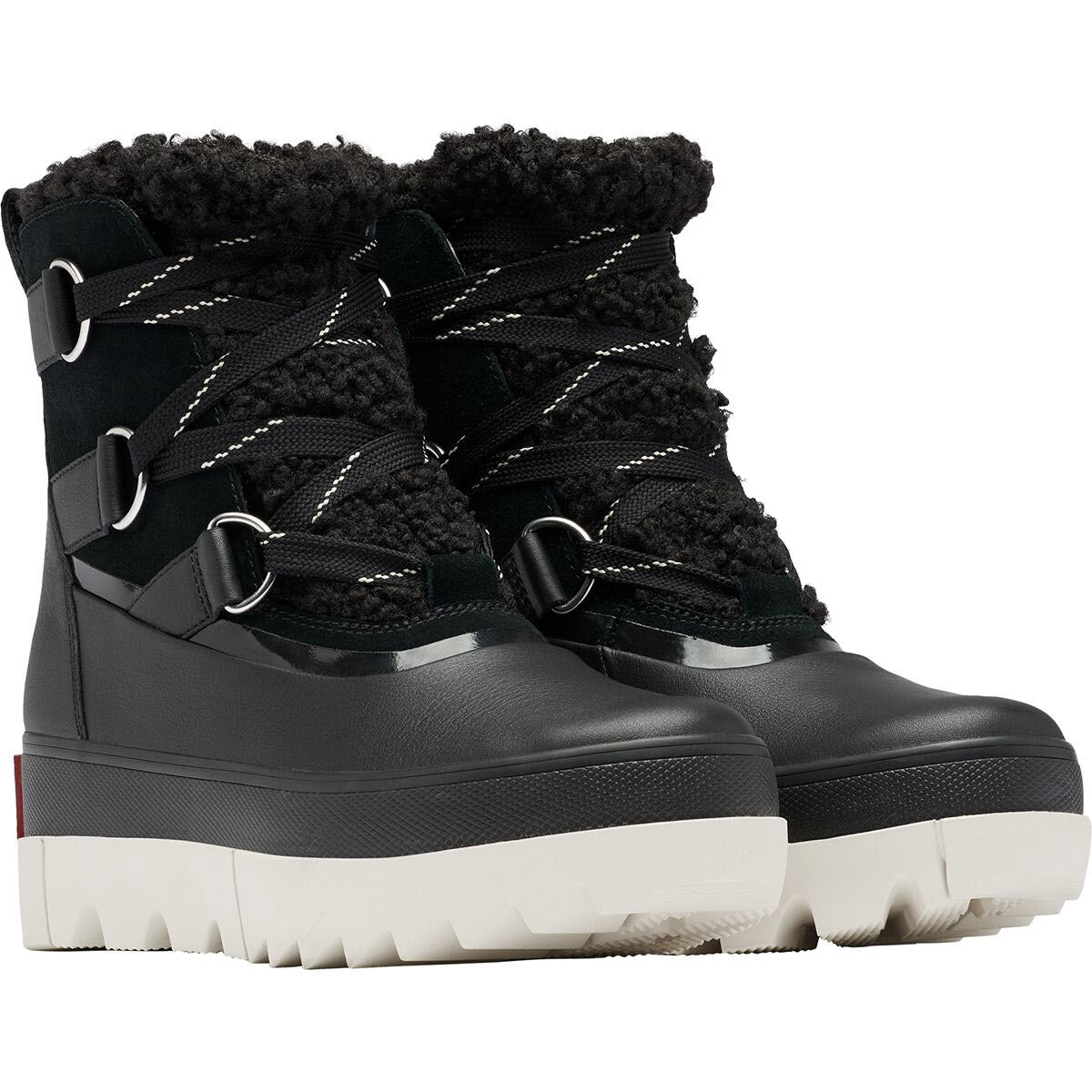 A pair of SOREL JOAN OF ARCTIC NEXT BOOT BLACK - WOMENS by Sorel with white, high-traction soles and thick black laces. The boots feature a fluffy black lining, metal eyelets for the laces, and waterproof construction to keep your feet dry in any condition.