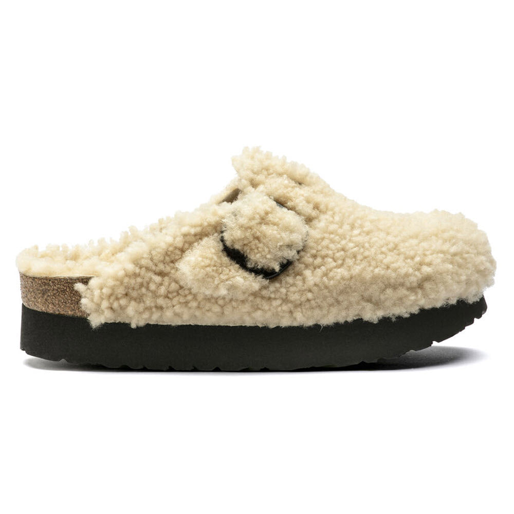 Side view of the Birkenstock Boston Platform Big Buckle Teddy Eggshell Shearling clog for women, showcasing a beige shearling-lined upper with a black sole and black buckle, featuring genuine shearling for ultimate comfort.