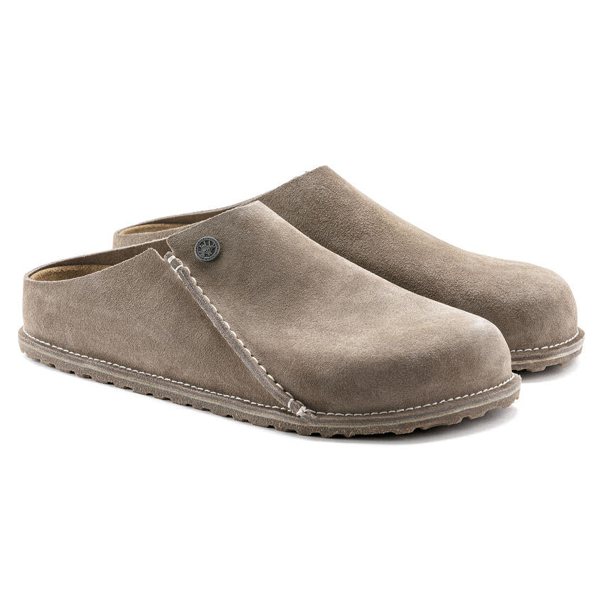 A pair of BIRKENSTOCK ZERMATT 365 GRAY TAUPE - WOMENS by Birkenstock with a rounded toe, stitching details, and a small metal button on the side, featuring ultimate slipper comfort and durable traction.