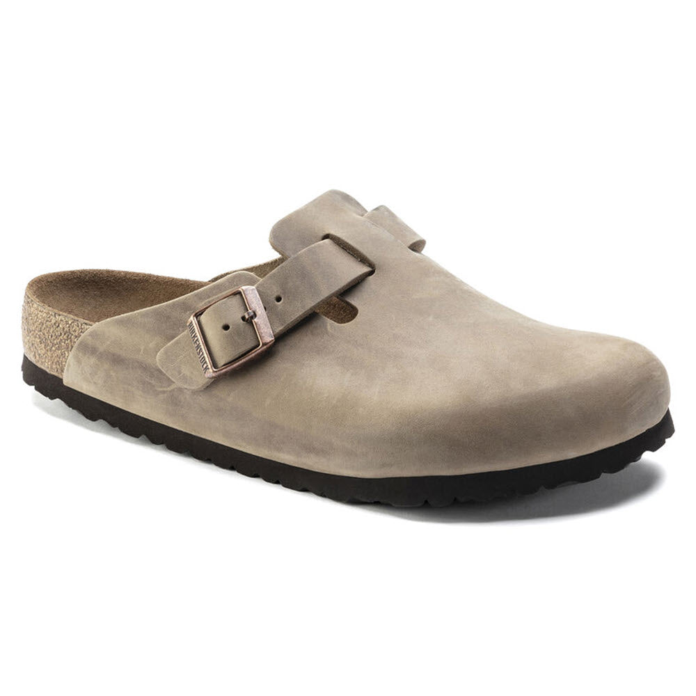 A single Birkenstock BIRKENSTOCK BOSTON TOBACCO LEATHER - ADULTS clog with a black rubber sole, featuring an adjustable buckle strap across the top and a luxuriously soft footbed.