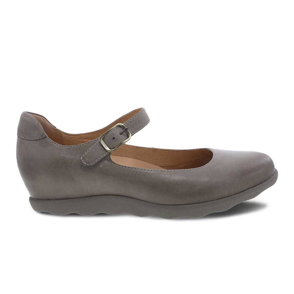 The Dansko Marcella Taupe Burnished - Women&#39;s shoe features a gray Mary Jane-style design with a single buckle strap, Dansko Natural Arch technology, and a contoured sole.