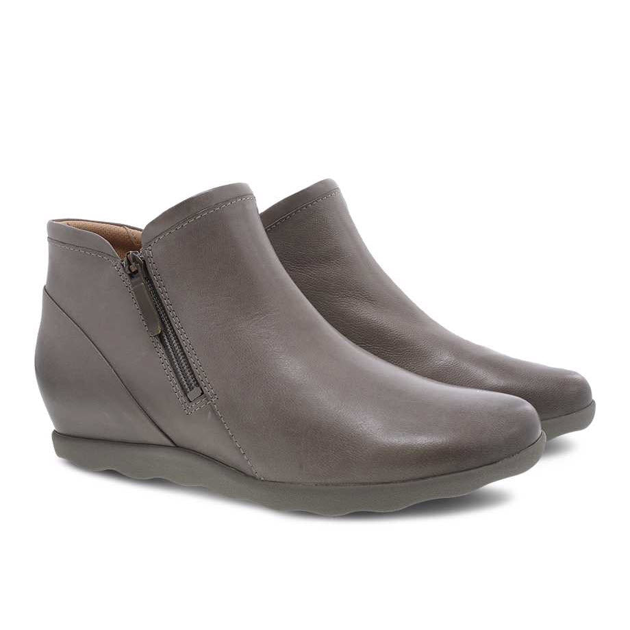 The DANSKO MIKI TAUPE BURNSIHED - WOMENS ankle boots by Dansko, in a taupe gray color, feature side zippers and a slight wedge heel. They are enhanced with Dansko Natural Arch technology for added comfort and are presented on a white background.