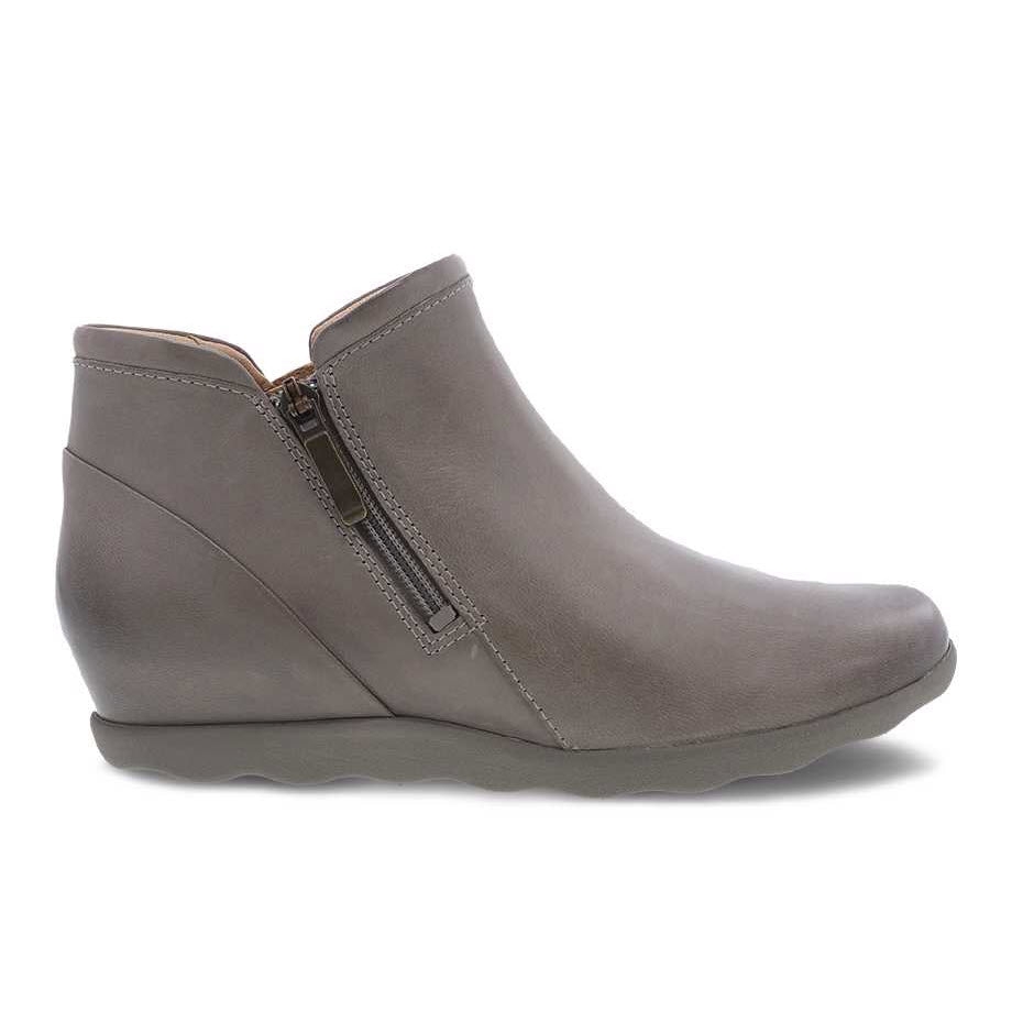 The Dansko Miki Taupe Burnished for women is a gray casual short bootie with a side zipper closure and a low wedge heel, designed in a minimalist style, featuring a removable PU footbed for added comfort.