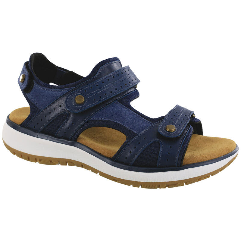 A blue open-toe outdoorsy sandal with adjustable straps, a cushioned tan insole, and a shock-absorbing white sole with brown treads. Introducing the SAS EMBARK SANDAL NEPTUNE - WOMENS by SAS.