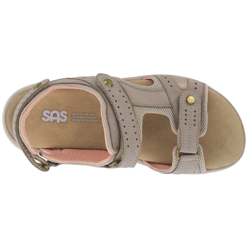 Top view of a single beige outdoorsy sandal with adjustable straps and a cushioned insole, labeled with &quot;SAS EMBARK SANDAL TAUPE - WOMENS&quot; from the brand &quot;SAS&quot; and text indicating it is made in the USA.