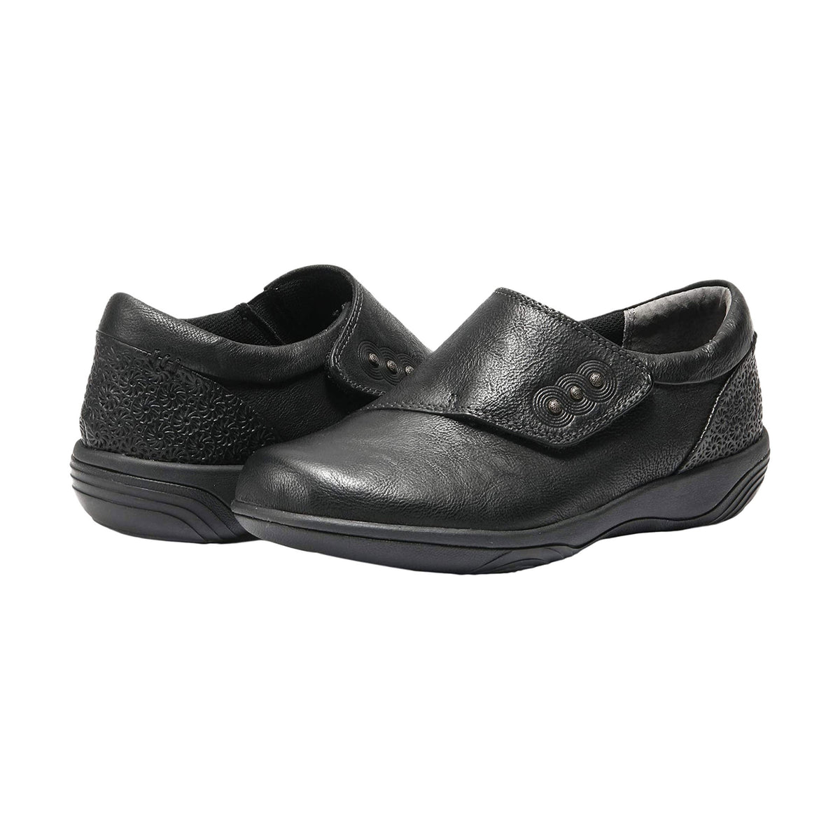 The Halsa Anna Black Leather shoes for women are slip-on black shoes adorned with textured details and decorative buttons, featuring leather uppers, a slightly elevated sole, and an anatomically correct insole for added comfort.