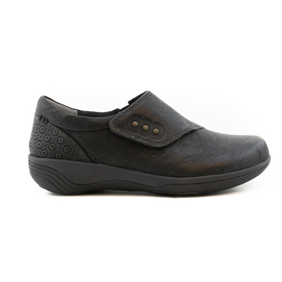 The HALSA ANNA BLACK LEATHER – WOMENS by Halsa is an orthopedic shoe featuring a black textured leather upper, an adjustable fastener, and a three-button detail. The sole is thick and contoured for added comfort.