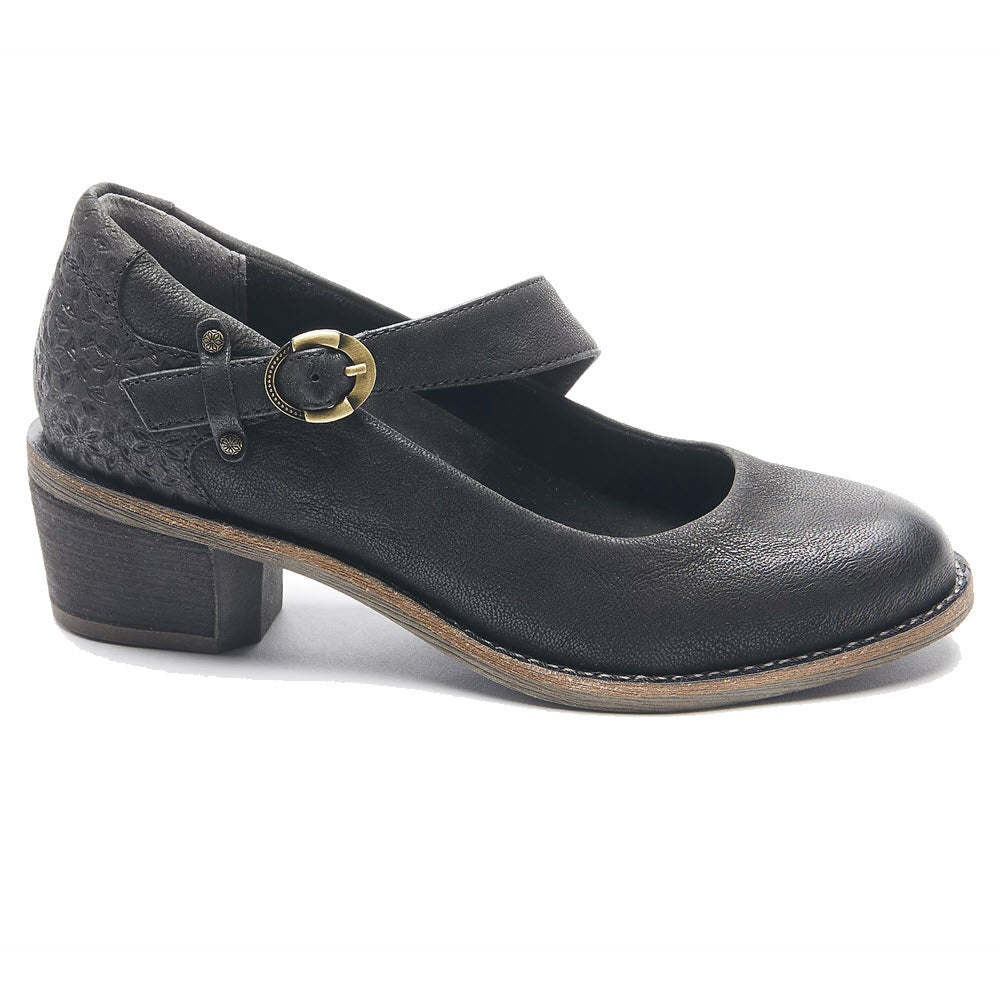 The HALSA MIA BLACK - WOMENS by Halsa is a Heeled Mary Jane with a retro-inspired silhouette, featuring a low block heel with a decorative pattern. Crafted from soft leather and adorned with a metallic buckle strap, it effortlessly combines style and comfort.