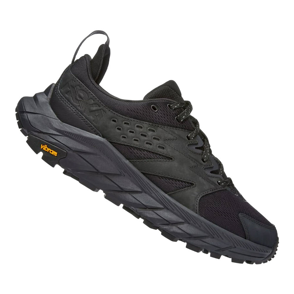 Black Hoka athletic shoe with a thick sole and a Vibram logo on the heel. The HOKA ANACAPA BREEZE LOW BLACK/BLACK - MEN boasts a mesh and synthetic material with a lace-up design, enhanced by an rPET engineered knit upper for added durability.