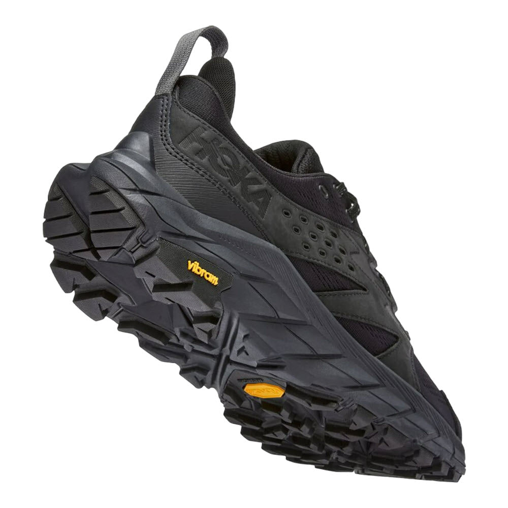 A black and gray athletic shoe with a rugged Vibram Megagrip outsole and HUBBLE heel geometry, designed for outdoor activities, such as the HOKA ANACAPA BREEZE LOW BLACK/BLACK - MEN by Hoka.