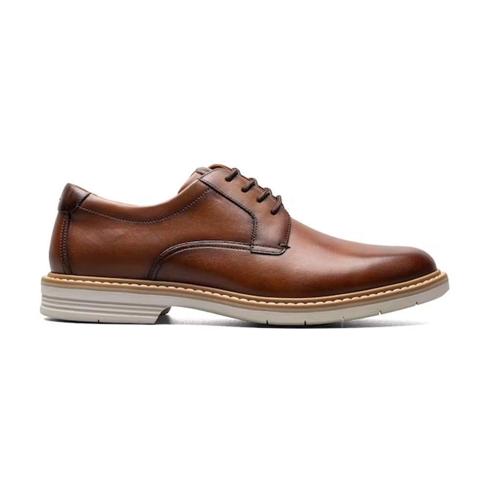 The FLORSHEIM NORWALK PLAIN TOE OXFORD COGNAC SMOOTH - MENS by Florsheim is a versatile shoe, featuring a single brown leather design with a beige rubber sole. The shoe is complete with laces and contrast stitching, perfect for any occasion.