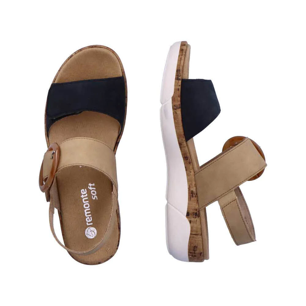 Two Remonte Comfort Big Buckle Sandals in black and tan, featuring beige and black adjustable straps, cork footbeds, and white outsoles. The left sandal is shown from the side, while the right sandal is shown from above.