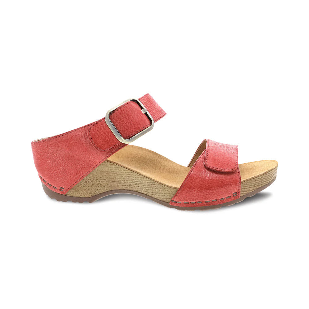 The DANSKO TANYA CORAL - WOMENS from Dansko is a red open-toe sandal featuring an adjustable ankle strap, a burnished leather upper, a wooden sole, and a light brown insole.