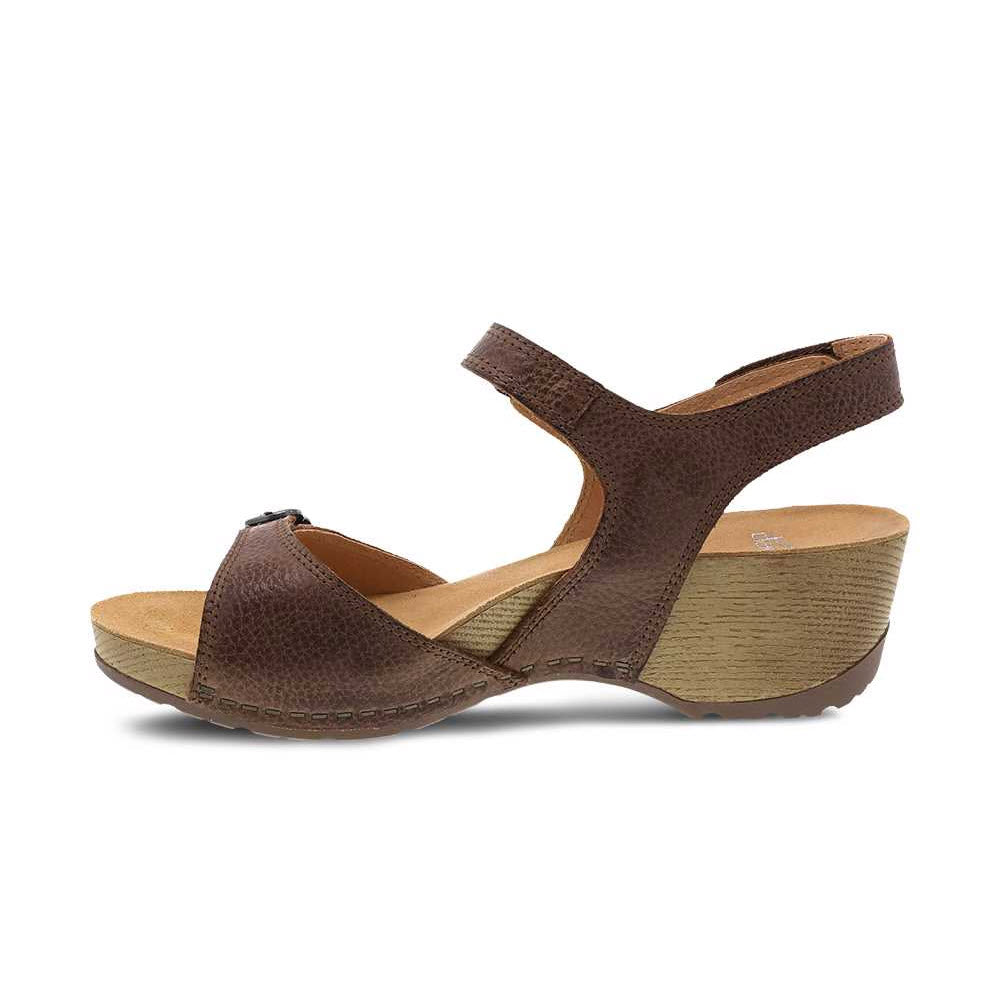 The DANSKO TRICIA BROWN - WOMENS by Dansko is a warm weather sandal featuring burnished leather uppers, an ankle strap, and a cushioned memory foam footbed.