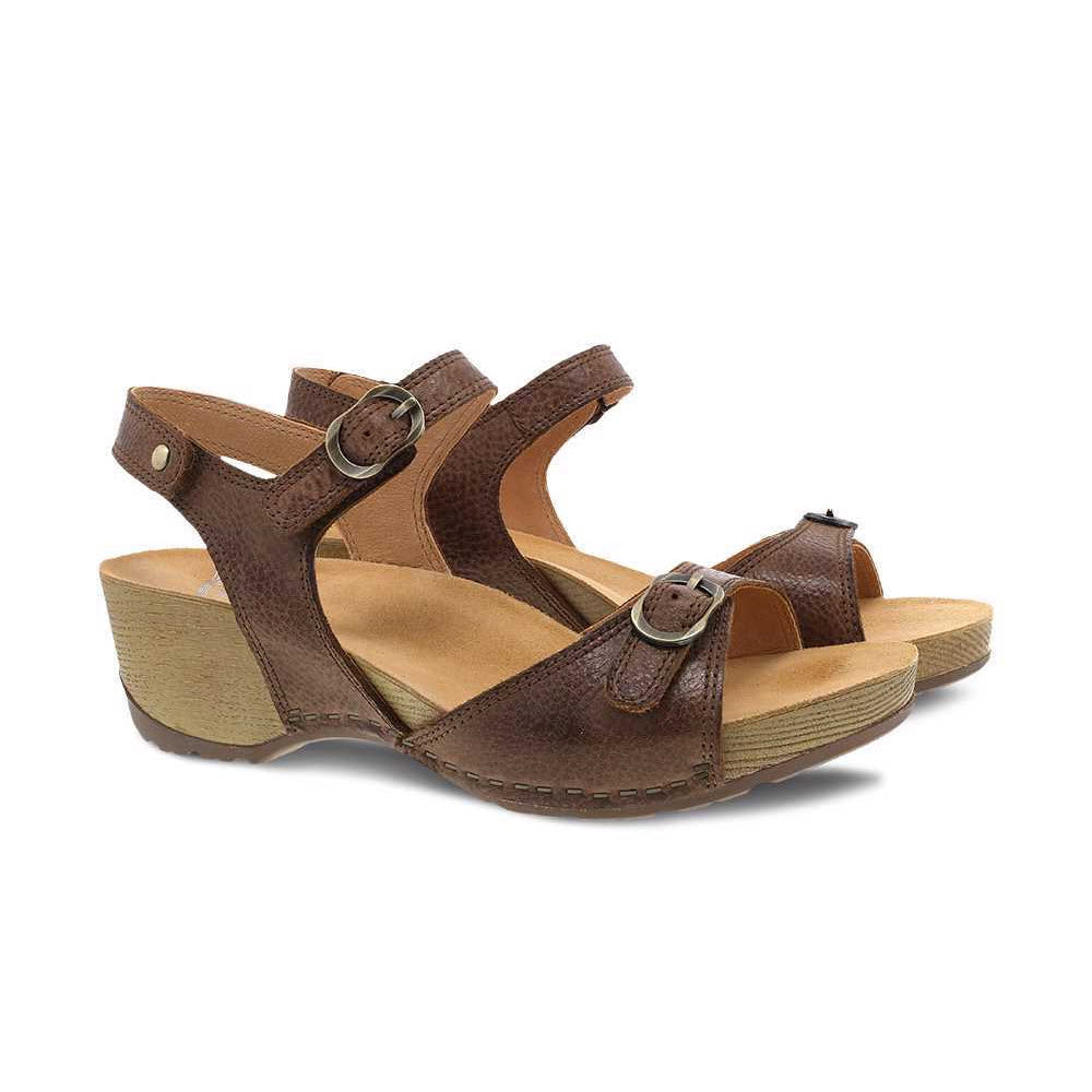 The DANSKO TRICIA BROWN - WOMENS, crafted by Dansko, are brown leather wedge sandals featuring adjustable ankle and toe straps with small metal buckles, offering premium comfort for warm weather.