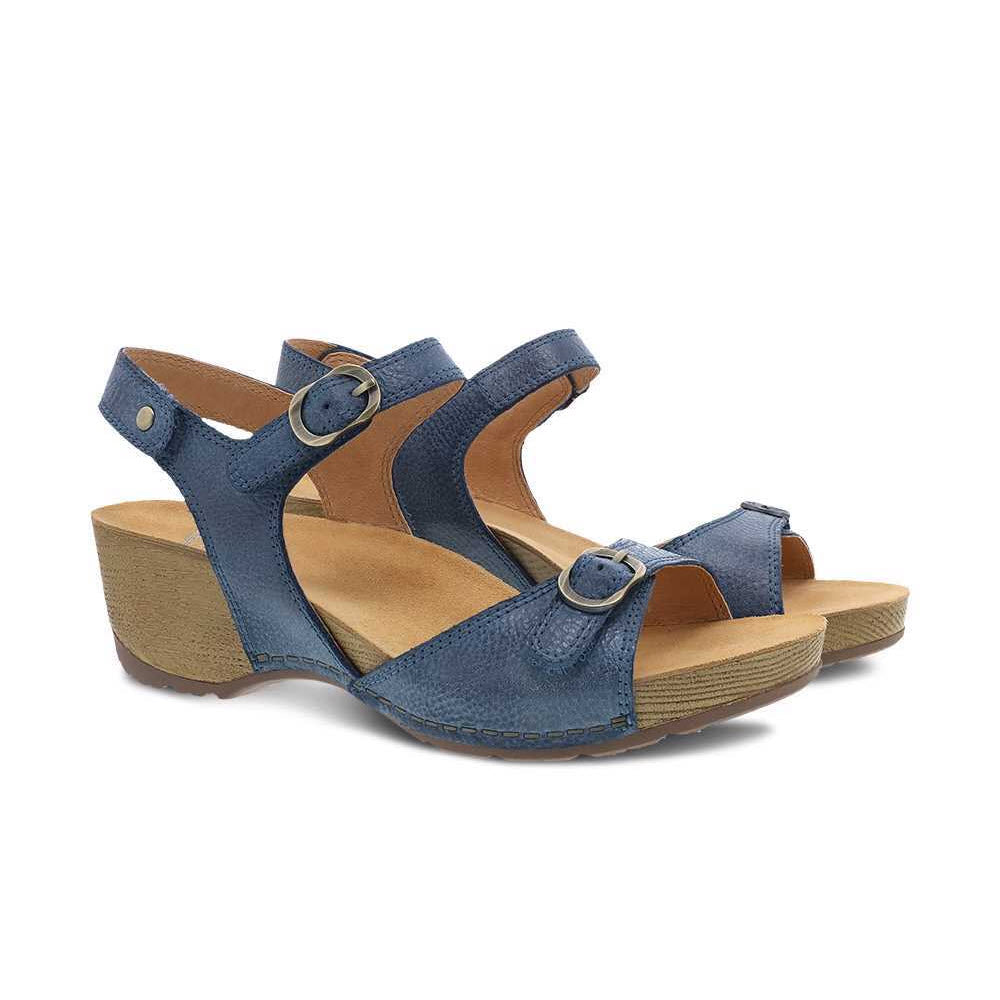 The DANSKO Tricia Blue women&#39;s sandals by Dansko feature adjustable buckle straps, tan footbeds, and premium comfort, making them perfect for warm weather.